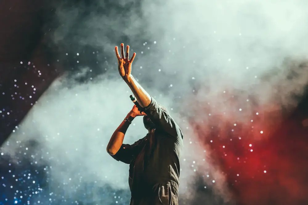 Chanteur pendant son concert avec de la fumée colorée en fond