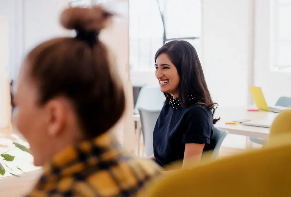 Femme souriant avec ses collègues lors d'une réunion au travail